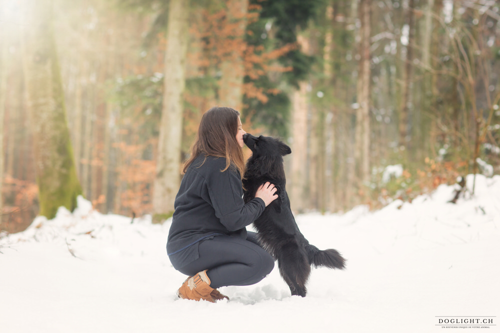 Portrait fille et son chien noir dans la neige